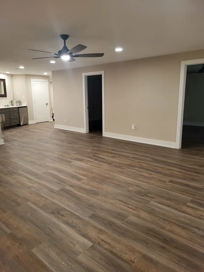 Open finished basement with kitchenette, fan, recessed lighting, and wood-look flooring